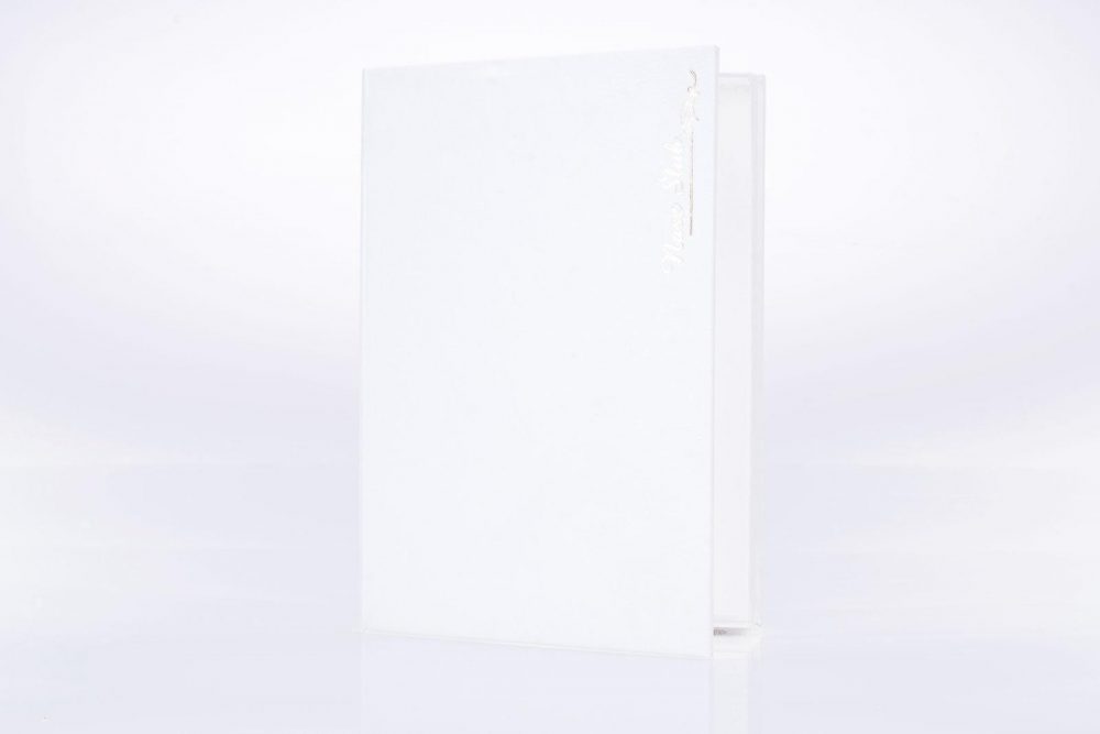 Białe pudełko na zdjęcia z złotym napisem „Nasz ślub”.
